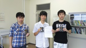 (ACM)記念品を掲げる受賞者の学生
